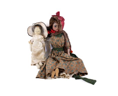 Two 18th century wooden dolls. Both having carved, turned and painted heads and torso. One with inset dark enamel eyes, paint