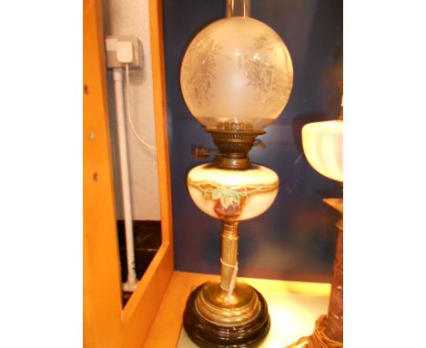 A Victorian oil lamp with acid etched glass shade and yellow glass reservoir hand-painted with grapes and vines, raised on a 