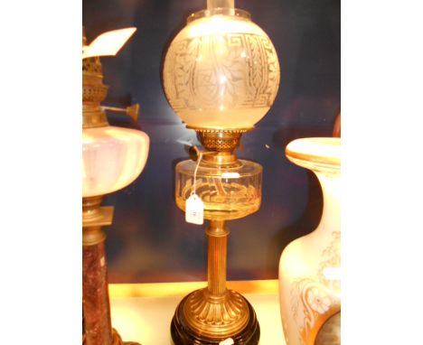A Victorian 'Express' ornate glass and brass oil lamp resting on painted terracotta base