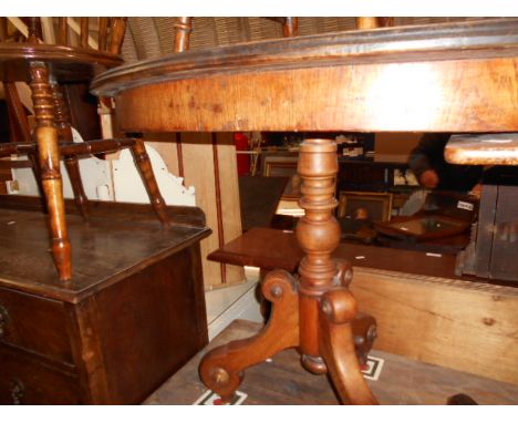 A small late Victorian oval mahogany centre table raised on turned column supports and three scrolling out-swept feet