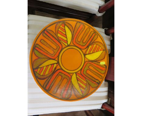 A Poole Pottery Delphis range charger, in orange and yellow, monogrammed on the base, 36 cm diameter 
