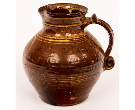 Michael Cardew (1901-1983), a Winchcombe Pottery slipware calligraphic jug of baluster form with scroll handle with traces of