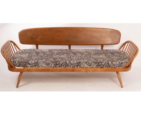 Lucien Ercolini for Ercol, an elm and beech sofa/daybed, with 'surfboard' back and curved spindled arms, 194cm wide/Note: The