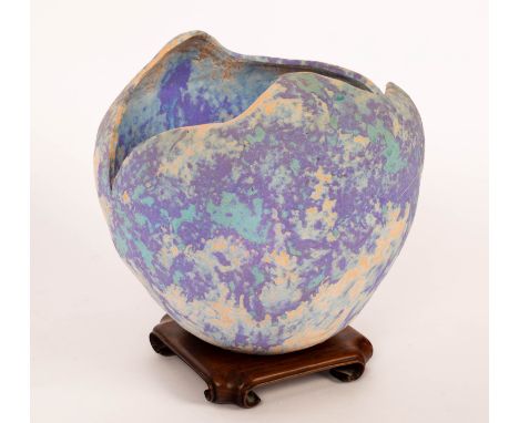A Studio ceramic vessel, of rounded form with irregular top, mottled blue, purple and ecru matte glazes, 23cm high