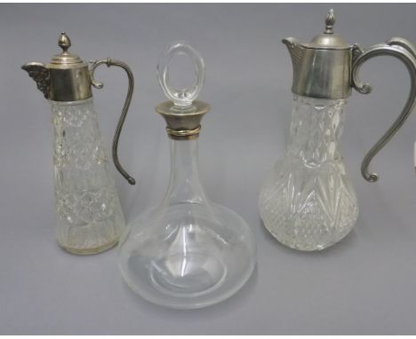 CARTIER SILVER AND GOLD RIMMED DECANTER AND TWO CLARET JUGS