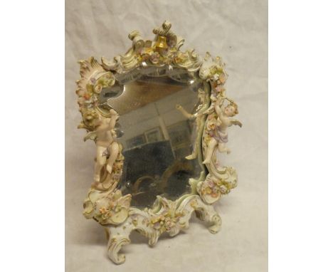 A German porcelain easel dressing mirror decorated in relief with cherubs and flowers, 15" high