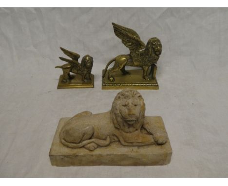 Two brass figures of winged griffins on rectangular bases and one other plaster figure of a recumbent lion (3)
