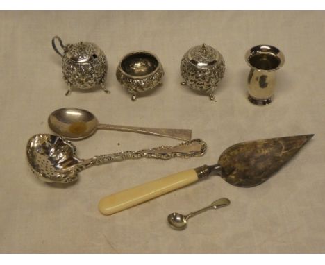 A small silver tapered vase, Art Deco silver preserve spoon, electroplated trowel, Indian silvered three piece cruet set, etc