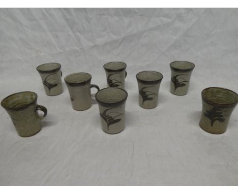 A set of eight 1960s Leach pottery tapered mugs with painted decoration