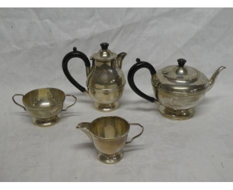 A George V silver four piece tea set comprising circular pedestal teapot with hinged lid and ebonised handle. Birmingham mark