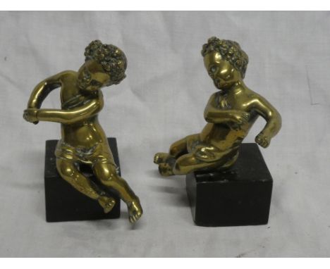 A pair of brass figures of classical cherubs on black marble bases, 5½" high