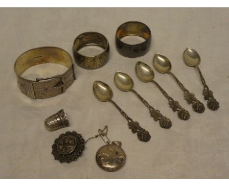 A silver circular pendant locket, silver thimble with ornate base, circular brooch and a silver circular bangle together with