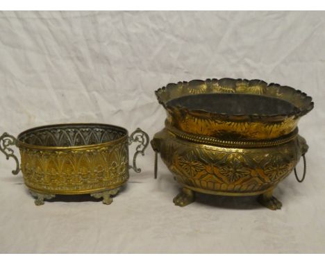 An old embossed brass oval two-handled planter with raised scroll decoration on paw feet, 14½" long and one other embossed br