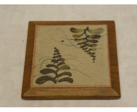 A 1960s Leach pottery square ceramic teapot stand with leaf decoration in wooden surround