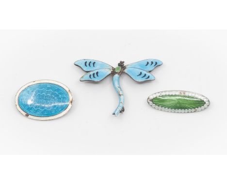 Three vintage guilloche enamel brooches comprising a dragonfly brooch and an oval brooch, with green engine turned centre wit