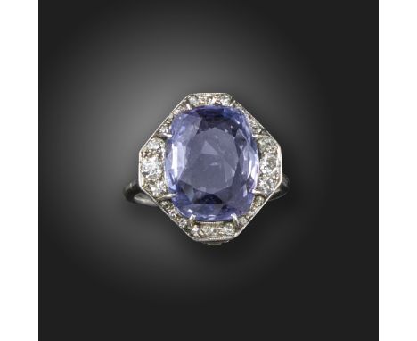 An Edwardian colour-change sapphire and diamond cluster ring, the cushion-shaped sapphire weighs approximately 6.00cts, set w