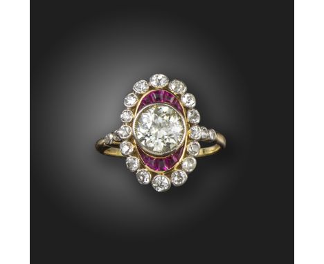 A ruby and diamond cluster ring, centred with an old circular-cut diamond within oval surround of calibre-cut rubies and old 