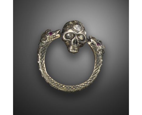 A diamond-set memento mori ring, the double headed serpents suspend a spinning skull between them, set overall with rose-cut 