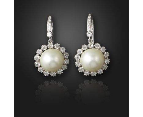 A pair of natural pearl and diamond drop earrings, the pearls set within a surround of old circular-cut diamonds, suspending 