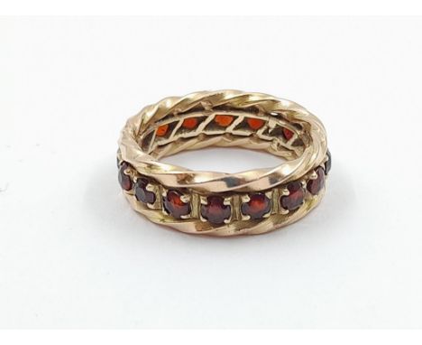 A vintage, 9 K yellow gold, full eternity ring with garnets. Ring size: M, weight: 5.27 g. In a presentation box. 