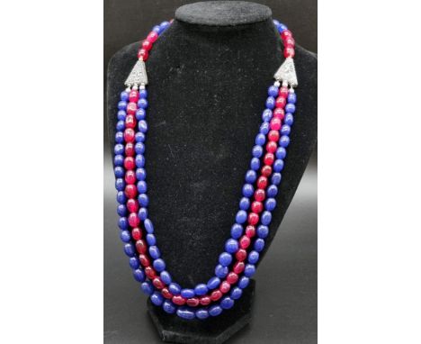 A Gorgeous 591ct Ruby and Sapphire Three-Strand Necklace. 8 x 15mm bands. Double clasp. 44cm. 