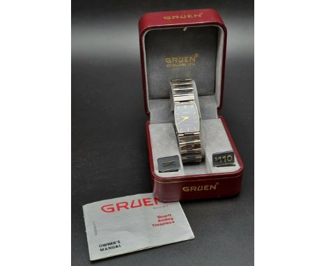 A VINTAGE GRUEN QUARTX WATCH IN ORIGINAL BOX WITH OWNERS MANUAL.