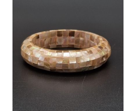 A Mother of Pearl Bangle. 7cm internal diameter. 