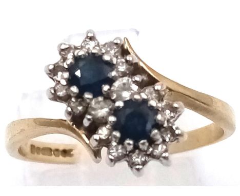 A 9 K yellow gold ring with a pair of blue sapphires surrounded by diamonds. Ring size: O, weight: 2.4 g. 