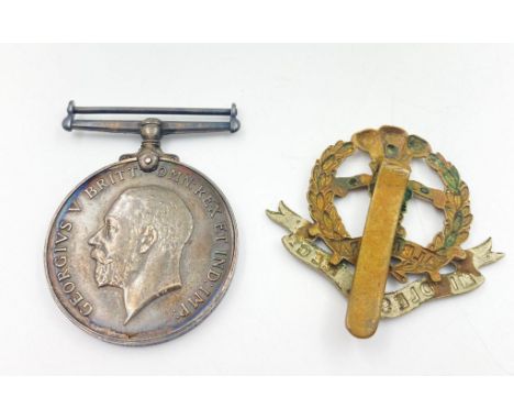 A WW1 Medal (Woods) and a Middlesex Regiment Cap Badge. 