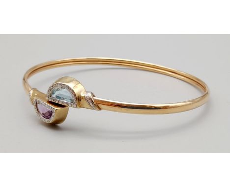 A 9K Yellow Gold  Amethyst and Topaz Bangle. 7cm inner diameter. 8.37g 
