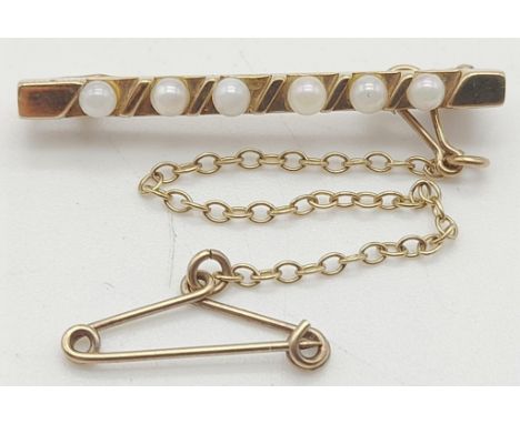 An Antique 14K Yellow Gold Seed Pearl Bar Brooch. With safety chain. 3cm. 2.25g total weight. 