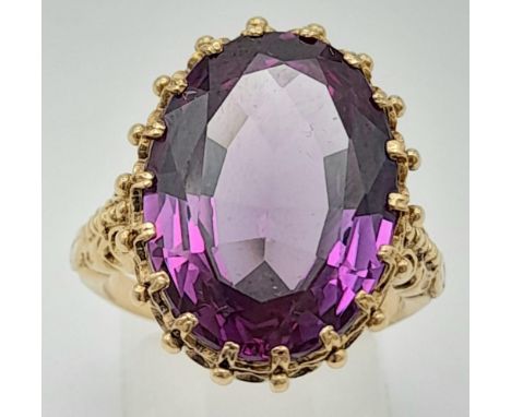 A 9K Yellow Gold Amethyst Ring. Beautiful large central oval cut amethyst stone  - 8cts. Size N1/2.  7.8g. 