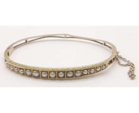 A Vintage 9K Yellow Gold and Seed Pearl Bracelet/Bangle. Graduated seed pearl decoration on one side. 6cm inner diameter. 5.5