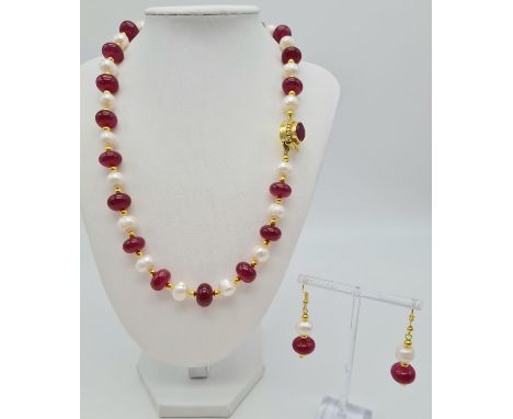 A glamorous necklace and earrings set with alternating genuine large pearls and ruby cabochons. Necklace length: 53 cm, earri