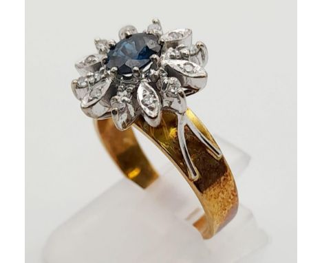 An 18K Yellow Gold Diamond and Sapphire Ring. Central sapphire surround by a halo of diamond petals. Size O.7.05g total weigh