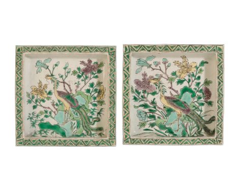 A PAIR OF CHINESE FAMILLE VERTE BISCUIT SQUARE DISHES, each painted with a phoenix among flowers issuing from rockwork within