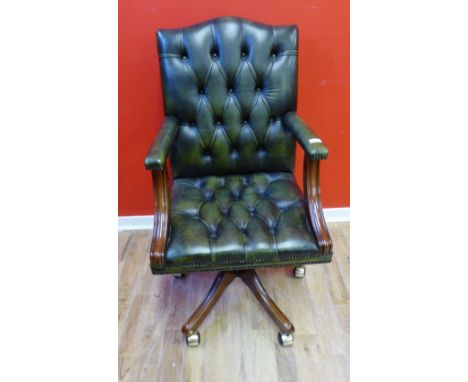 A reproduction green leather button back swivel chair