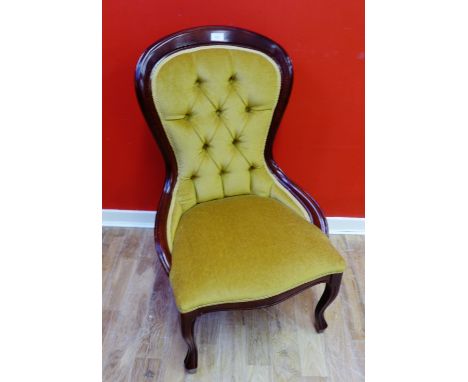 A reproduction mahogany framed button back nursing chair raised on cabriole legs