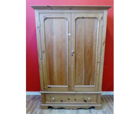 A pine two door wardrobe having two panel doors above single drawer raised on bracket feet, 133 x 200cm