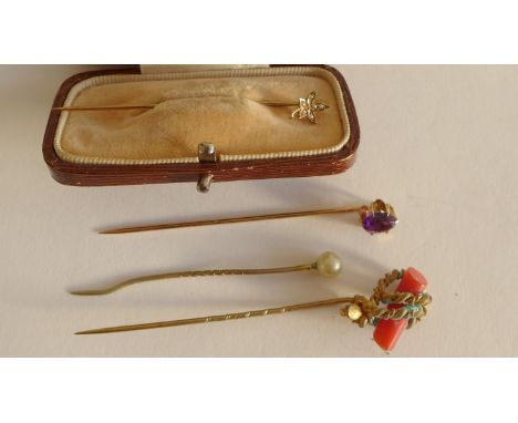 A 10 carat gold and seed pearl stick pin together with three others (4) 