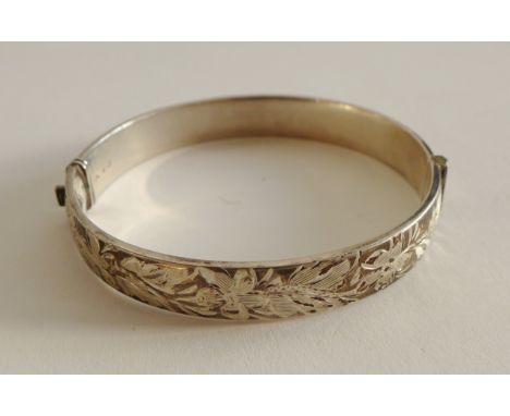 A Sheffield silver stiff hinged foliate engraved bangle 