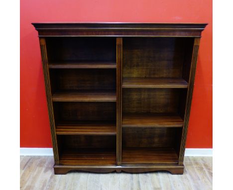 A reproduction mahogany bookcase with a moulded top above six adjustable shelves , raised on bracket feet, 122 x 130 cm 