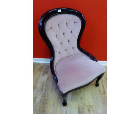 A reproduction mahogany framed chair with button back support and stuff over seat raised on moulded feet, 