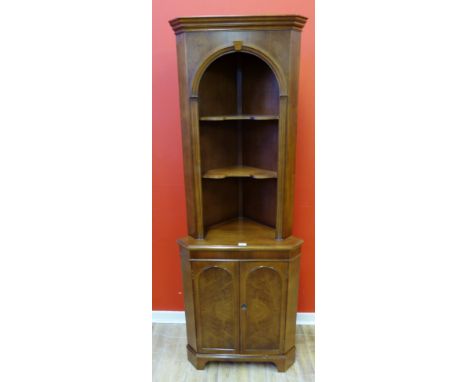 A mahogany corner cabinet having two shelves above panel door cabinet raised on bracket feet, 64 x 180cm