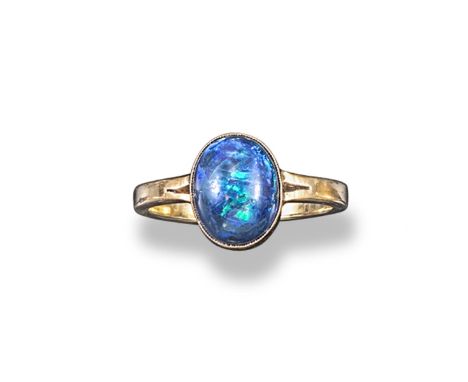 An opal single stone ring, the solid black opal cabochon is set in yellow gold. Size T.