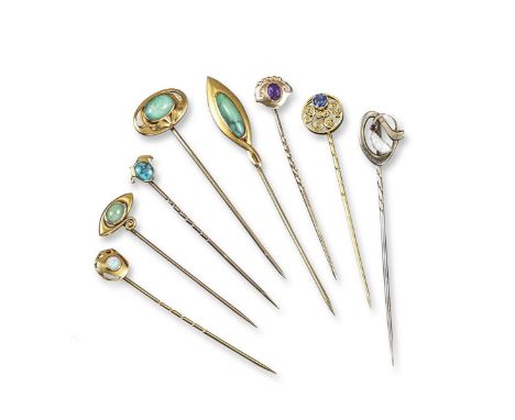 A collection of eight Arts and Crafts gold stick pins, all cased, including a gold stick pin mounted with a circular cut sapp