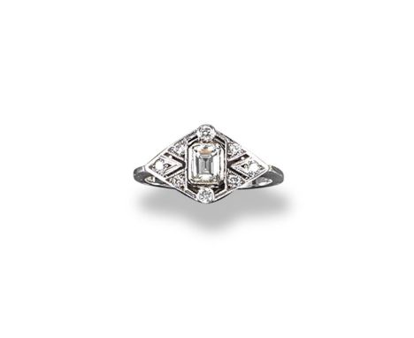 A lozenge-shaped diamond ring, the centre emerald cut diamond is set within a surround of smaller circular cut diamonds in wh