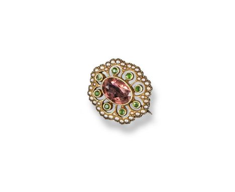 An Edwardian gem-set gold brooch, centred with an oval-shaped pink topaz within a surround of demantoid garnets and seed pear
