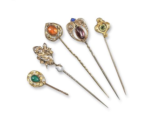 A silver-gilt stickpin mounted with a garnet cabochon and square blue stone, with scrolling wirework. Signed to the reverse M