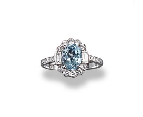 An aquamarine and diamond cluster ring, the oval shaped aquamarine is set within a surround of circular-cut and baguette-shap